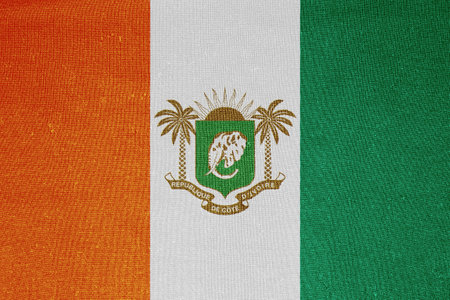 Flag and coat of arms of the Republic of Cote d'Ivoire on a textured background. Concept collage.の写真素材