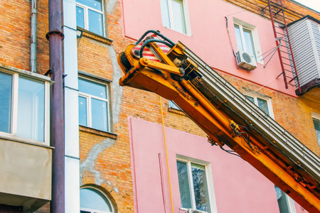 A crane against the background of an old brick apartment building.の写真素材