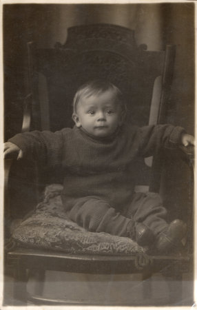 Vintage photo of a little cute boy sitting in a chair. USSR, Rostov. 1939.の写真素材