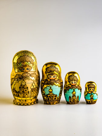 Four nesting dolls, Russian wooden doll on a white background. Gold color with Orthodox houses. Vertical.の写真素材