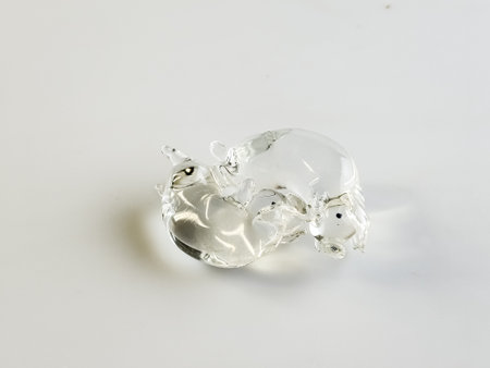 Glass figurine in the form of kissing piglets on a white background.
