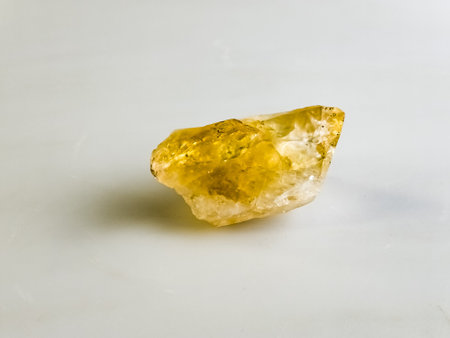 Natural stone of untreated citrine crystal, yellow quartz. Selective focus, white background.