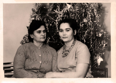 Retro photograph of mother and adult daughter near New Year tree. USSR, 1971.の写真素材