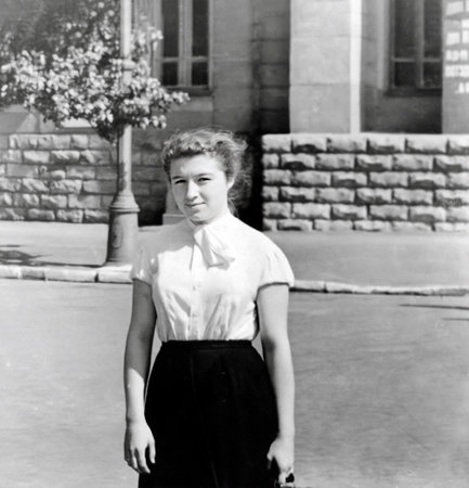 Vintage portrait of a seventeen year old girl in a white blouse and black skirt. Retro photo from 1956.の写真素材