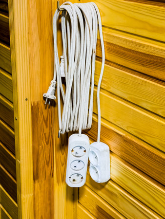 Extension cords on spacers on wooden walls in a country house. Professional electrician equipment.の写真素材