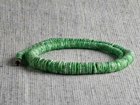 Handmade polished green shell pieces necklace as a gift for a woman on gray background. Natural jewelry. Summer jewelry.の写真素材