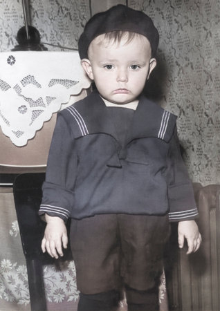 Vintage portrait of a little boy in a beret and a sailor suit. The boy is upset. Retro photo from 1968.の写真素材
