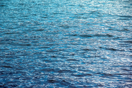 Water background of lake Traunsee in Alps. Colorful texture of reflections of a clear mountain lake....