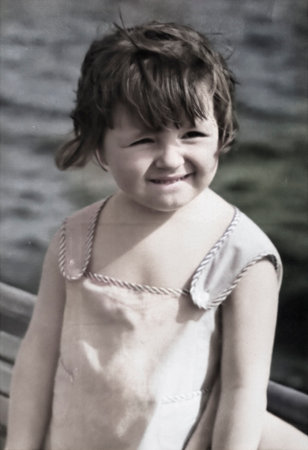 A vintage portrait of a five-year-old girl on the riverbank. Retro photo from 1972.の写真素材