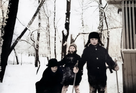 Luga, USSR - December 1, 1970: Vintage portrait of a mother and laughing young children playing in the snow in winter. Retro photo.のeditorial素材