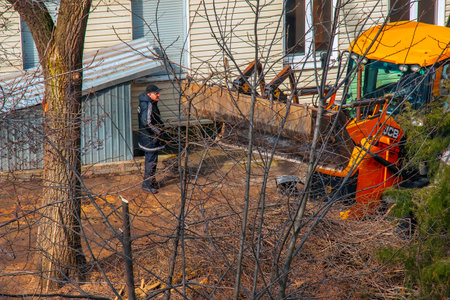 Dnepr, Ukraine - 03.20.2024: A bulldozer collects branches after pruning trees.