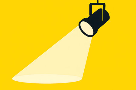 Spotlight shines on a yellow background, the light beam creates a sense of focus and attention.の素材