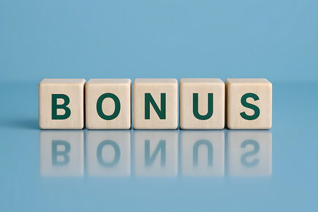 Five wooden blocks spell the word BONUS on a reflective light blue surface, creating a clear and positive message.の素材