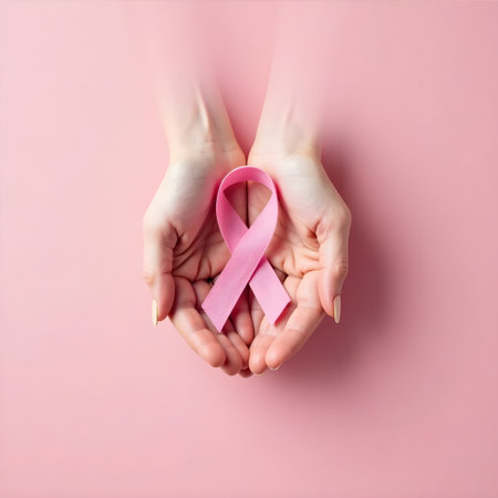 Hands tenderly hold a pink ribbon, symbolizing compassion and support on a soft pink backdrop.の素材