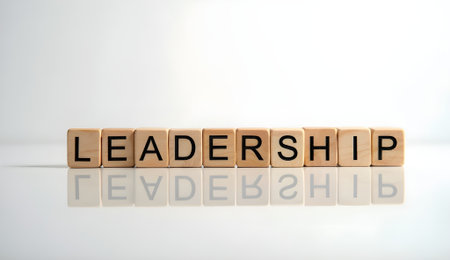 Wooden block engraved with Leadership placed on reflective surface against white backgroundの素材