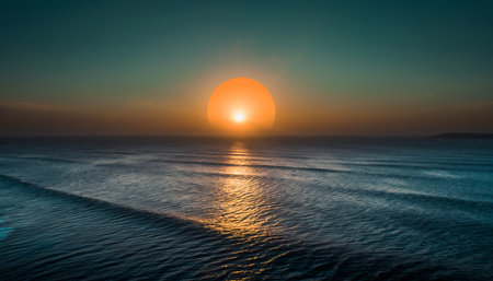 Majestic orange sun setting over the calm ocean, casting a golden reflection on gentle wavesの素材