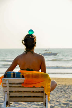 Practicing balance and awareness is good for the health and spiritual growth. Here a woman is practicing the same while relaxing at beach of the Goa.の写真素材