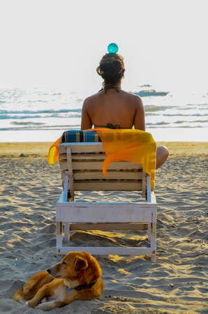 Practicing balance and awareness is good for the health and spiritual growth. Here a woman is practicing the same while relaxing at beach of the Goa.の写真素材