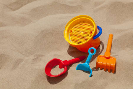 Children's beach toys - buckets, spade and shovel on sand on a sunny dayの写真素材