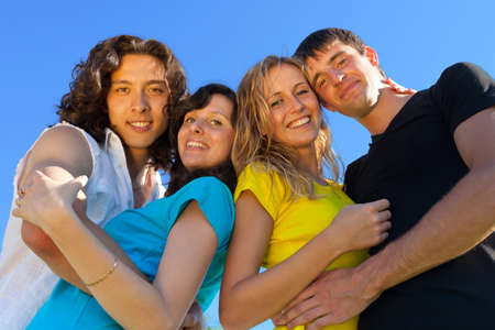Young people, two girls and two boys, hugged each other and smileの写真素材