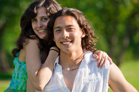 A pretty girl in a park put his arm around her boyfriendの写真素材