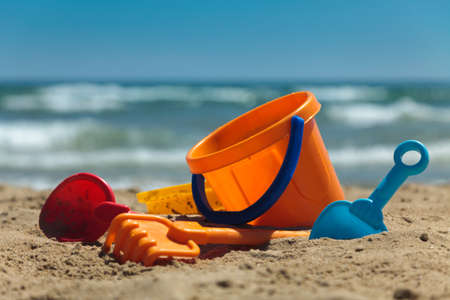 Children's beach toys - buckets, spade and shovel on sand on a sunny dayの写真素材