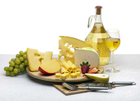 Composition of cheese, grapes, bottles and glasses of wine and strawberries on a wooden round tray on a white tablecloth, isolated on a white backgroundの写真素材