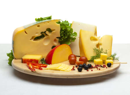 Composition of cheese on a wooden round tray on a white tablecloth, isolated on a white backgroundの写真素材