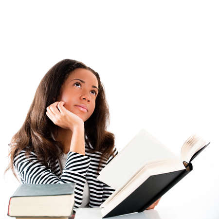 Young and beautiful smiling student with open book reading and thinkingの写真素材