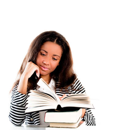 Young and beautiful smiling student with open book reading with hand resting on chinの写真素材