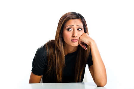 Young beautiful unhappy Asian Indian teenager glancing with face resting on hand の写真素材