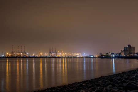 Beautiful night view of the South Pier of Callao reflecting into the ocean in Lima, Peruの写真素材
