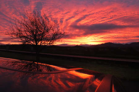 Cloudy Sunrise in Killarney with reflection on the car roofの写真素材