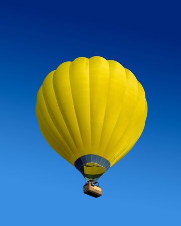Yellow hot air balloon flying on dark blue sky backgroundの写真素材