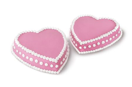 Two pink heart shape marzipan cakes decorated with white whipped creamの写真素材