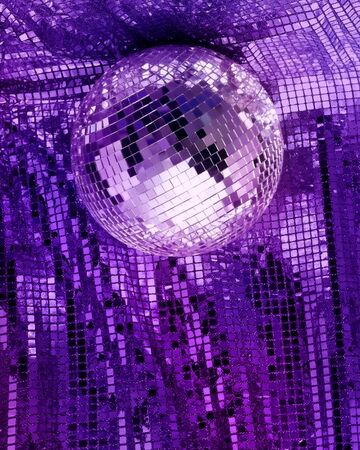 Purple disco mirror ball reflect light on glitter canvas backgroundの写真素材