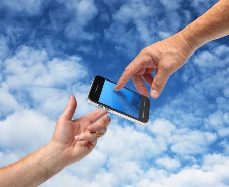 Two hands reaching smartphone, communication conceptの写真素材