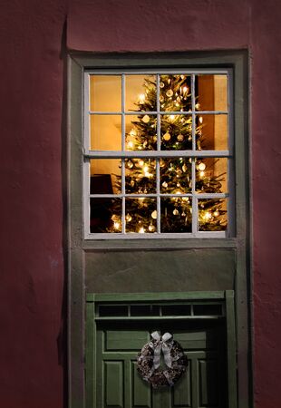 Christmas tree seen from outside of an old house windowの写真素材