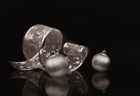 Sepia toned silver ribbon and Christmas balls on dark backgroundの写真素材