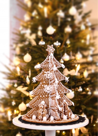 Gingerbread Christmas tree on real fir tree backgroundの写真素材