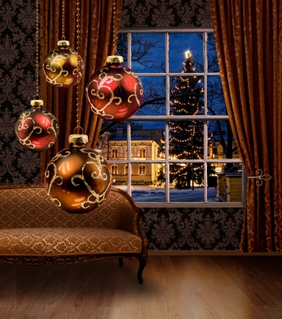 Christmas balls hanging in front of town view window, classic furniture interiorの写真素材