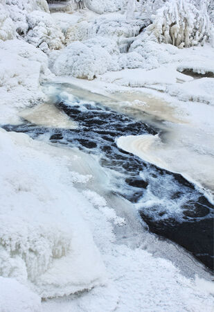 Frozen creek in winter, icy waterの写真素材
