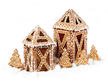 Gingerbread cookies cottages isolated in white snow の写真素材