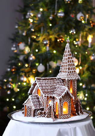 Decorated gingerbread church with Christmas tree on backgroundの写真素材