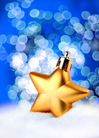 Golden Christmas decoration star on blue bokeh backgroundの写真素材
