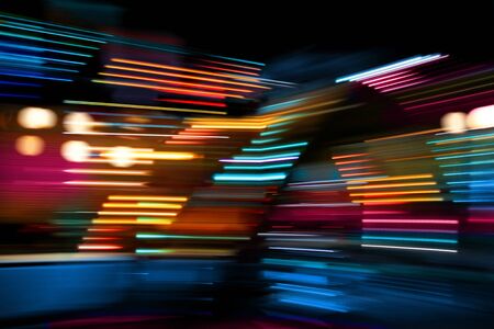 Colorful lights of urban city surrounding moving and blurred by motionの写真素材