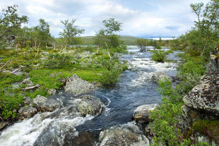 Lake Tsahkal and running streamlet in Northern Lapland Finnish wildernessの写真素材