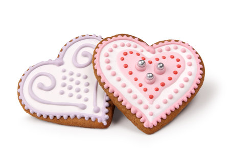 Two heart shaped decorated Christmas gingerbreads isolated on whiteの写真素材