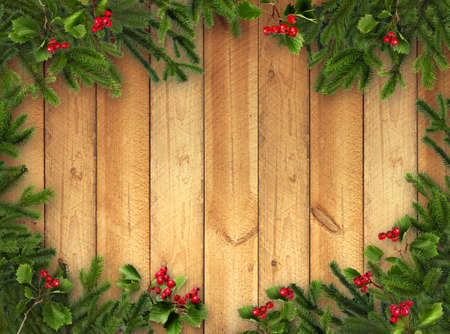 Green Christmas tree branches and red hawthorn berries on warm brown wooden vertical plank wall backgroundの写真素材