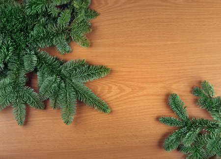 Green Christmas fir tree spruce branches on wooden backgroundの写真素材